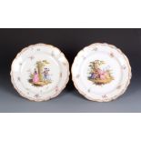 A pair of Meissen saucer dishes, each painted after Watteau with a couple in a landscape,