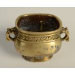 A Chinese oval, two handled ding shaped censer decorated with a border of stylised clouds,