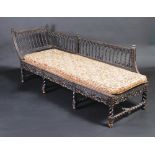 An ebonised ornate carved chaise longue in eastern style, with spiral pillars.
