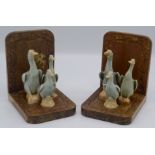 A pair of carved wood book ends, each with three Chinese celadon porcelain figures of ducks,