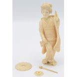 A Japanese ivory okimono, a geisha holding a fan in one hand, height 13cm.