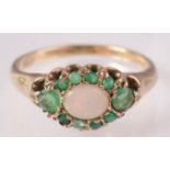 A 9ct gold opal and emerald oval cluster ring.