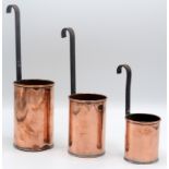 Three copper measuring dips with iron handles.