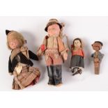 A clockwork tin plate doll, a German figural wooden bottle stopper and two other dolls.