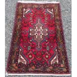 A Hamadan rug, north west Persia, the red field with an ivory lobed medallion,