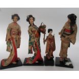 Four Japanese geisha dolls, in traditional costume, one musical, height of largest 38cm.