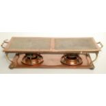 A copper plate warmer with brass handles and curvilinear supports, width 68.5cm.