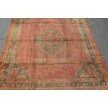A Turkish Ushak carpet, the madder field with a polychrome stepped medallion, with vines and guls,