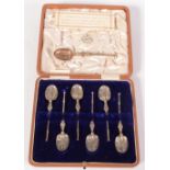 A set of six silver copies of the anointing spoon, cased,