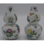 A pair of Chinese porcelain double gourd vases decorated with floral sprays, red seal mark to base,