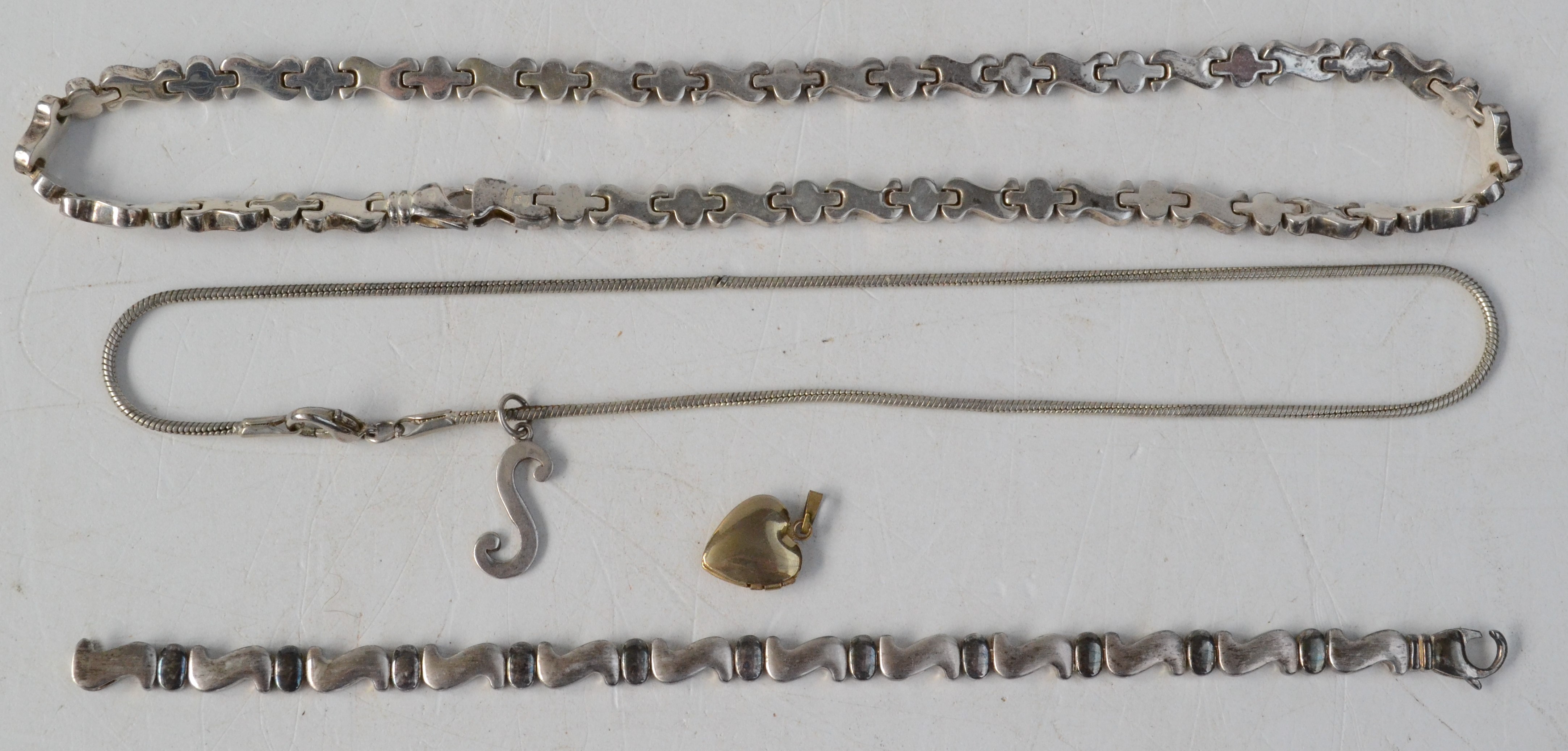 A silver 'S' pendant and snake chain,