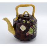 A majolica teapot, with a rustic handle and spout,