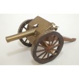 A model of a military brass cannon, on a wooden carriage, total length 25cm, height 10.5cm.