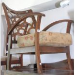 A 1930s low open armchair with a fret cut cloud back and arched arms.