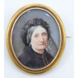 A Victorian brooch set a portrait miniature of an elderly lady, the back with a lock of hair.