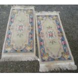 A pair of Chinese rugs, the ivory field with a central floral medallion,