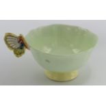 A Paragon fine bone china butterfly handled tea cup, with pale green and yellow body, height 6.5cm.