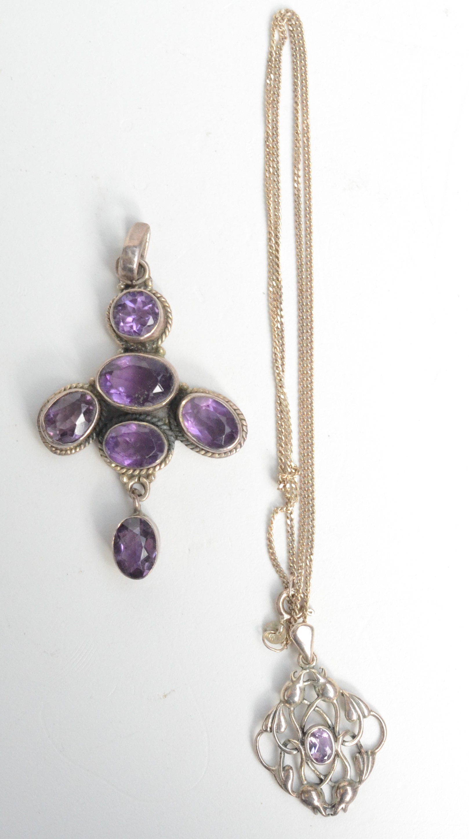 An Arts and Crafts style silver pendant set amethyst and one other amethyst and silver pendant.