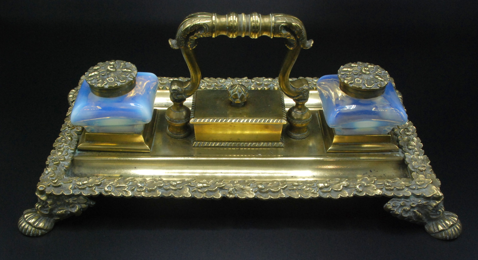 A handsome Regency brass ink stand with oak branch borders and vase shaped vaseline glass inkwells.