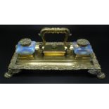 A handsome Regency brass ink stand with oak branch borders and vase shaped vaseline glass inkwells.
