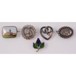 An 1887 silver brooch, a niello enamel and gilt silver brooch and three other brooches.