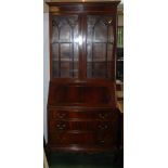 A Georgian style mahogany veneered slope front bureau bookcase.