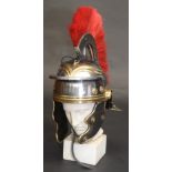 A reproduction Roman soldier's metal helmet, on a plaster classical bust, height 55cm.