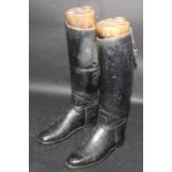 A pair of black leather riding boots with wooden trees inscribed to inner sole 'hand lasted for