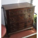 An early 18th century oak chest with three small drawers over three long graduated drawers,