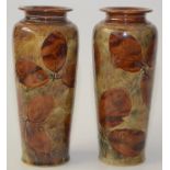 A pair of Royal Doulton stoneware vases decorated with leaves, signed to base JH,