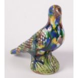 A Chinese san sai mottle enamelled biscuit ware porcelain figure of a bird upon a rocky base,