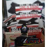 A box of Rolling Stones mugs and other collectibles and a card sign advertising the Love is Strong