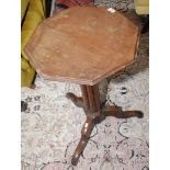 An octagonal tripod pedestal occasional table standing on three feet.