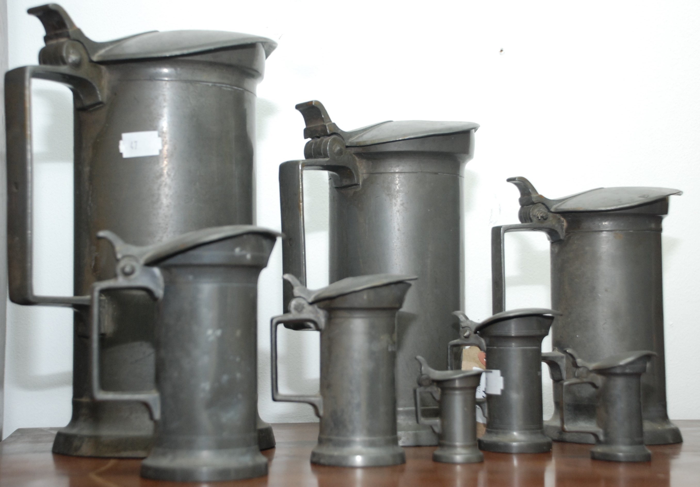 Eight French pewter measures, ranging from 'double litre' to 'centilitre', maker's mark to base,