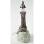 A Cornish serpentine lighthouse lamp, with a seagull perched on a stylised rock base, height 38cm.