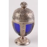 A lidded egg shape jar cast with leaves, flowers and fruit and with a blue glass liner,
