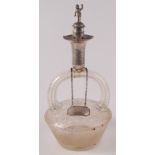 A Victorian engraved glass stirrup form decanter with engraved silver mounts and sculptural stopper