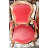 A Victorian walnut salon armchair upholstered in red dralon.