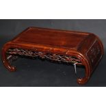A Chinese huali wood Kang table, the frieze carved with scrolling vines, serrated leaves and fruit,