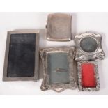 Four silver mounted photograph frames and a silver engine turned cigarette case.