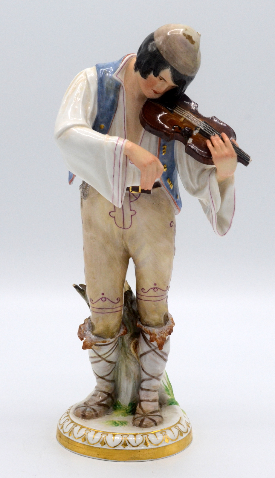 A Meissen porcelain figure of a gypsy violinist, 19th century, incised R127 and blue crossed swords,