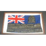 A blue ensign flag decorated with naval cap tallies, all in a mahogany framed display case,