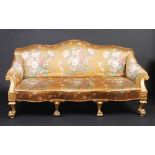 A good early Victorian carved gilt upholstered sofa, the arms with scrolling supports,