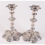 A pair of Victorian filled silver crested candlesticks in mid 18th century style by John Knowles &