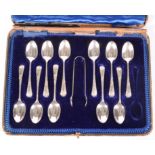 A set of eleven engraved silver teaspoons and matching tongs.