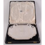 A shaped silver square tray on four scrolling legs inscribed and dated 1962. 29oz. Fitted case.