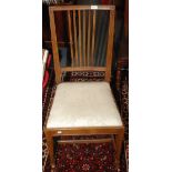 An early 20th century oak dining chair with a drop in seat, on tapering legs.