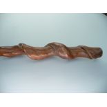 A tribal carved wood spiral twist club with leather handle, length 78cm.