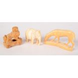 An ivory figure of a dog, length 6cm, an elephant and a mythical creature.
