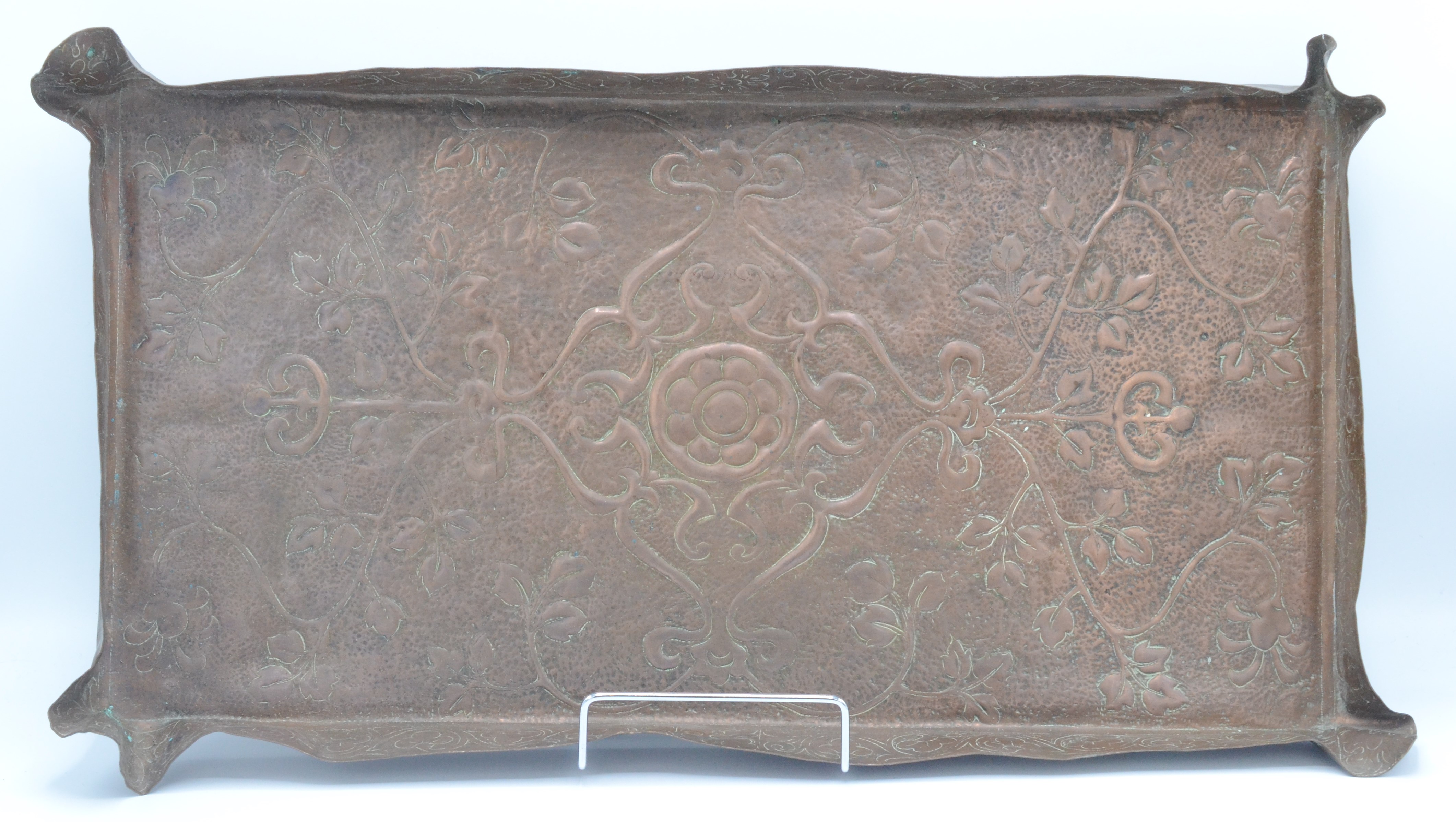 An Arts and Crafts rectangular copper tray, decorated with leafy vines and a central flowerhead,